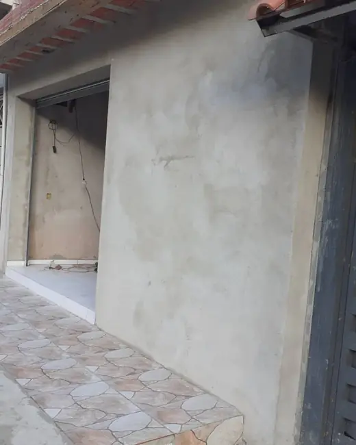 Fachada de casa rebocada, com piso cerâmico na calçada